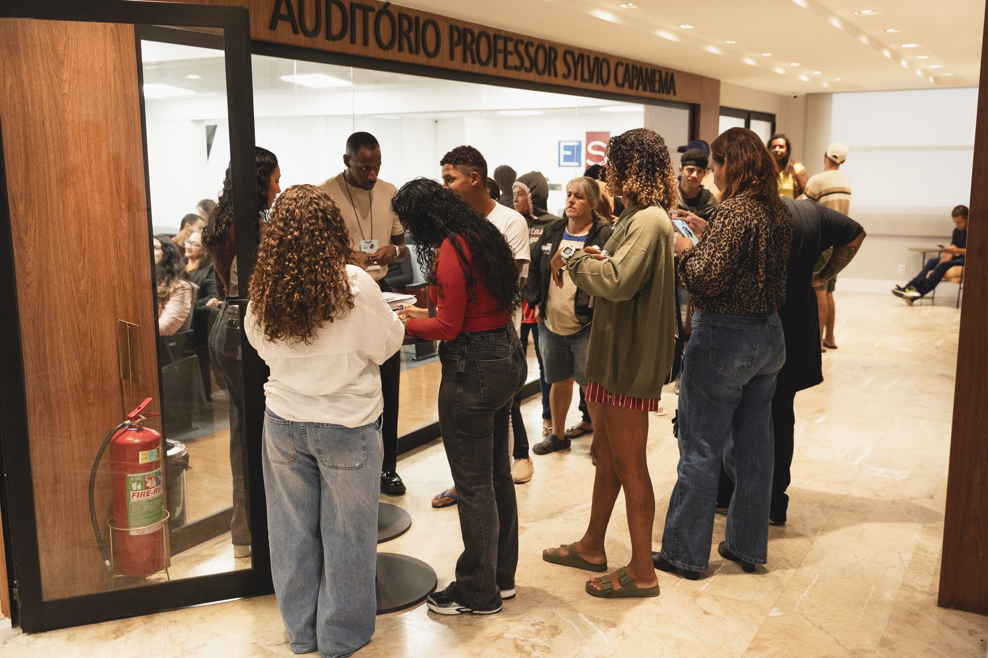 Participantes reunidos na entrada do auditório durante encontro do projeto Comum Viver